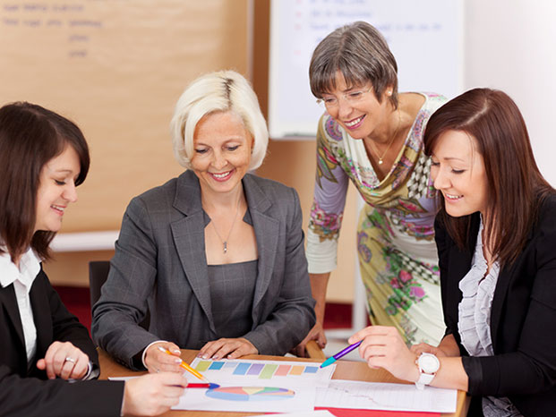 Fachveranstaltung / Meeting mit 4 fröhlich lächelnden Frauen am Tisch